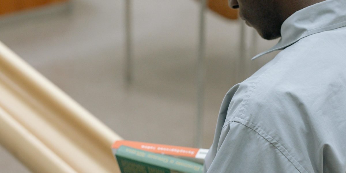 A person focused on reading, embodying the careful evaluation of a book sample before committing to a purchase.