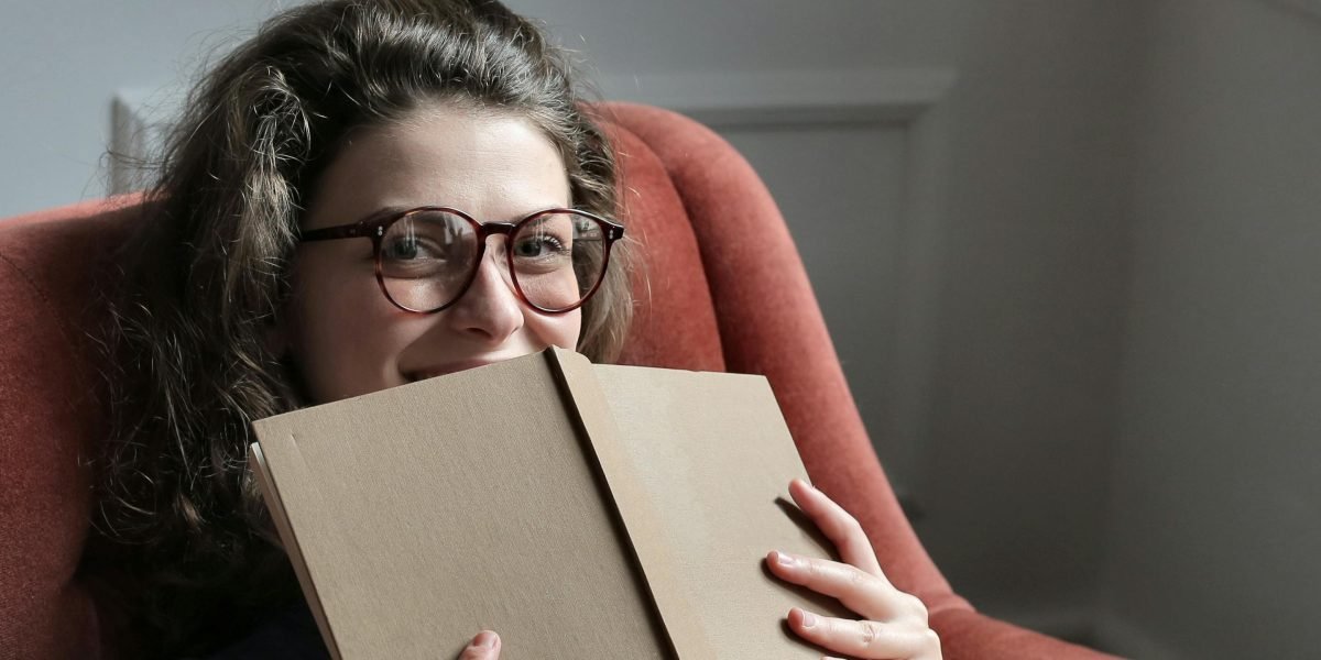A person joyfully discovering new books, illustrating the exploration and satisfaction found with services like Kindle Unlimited.
