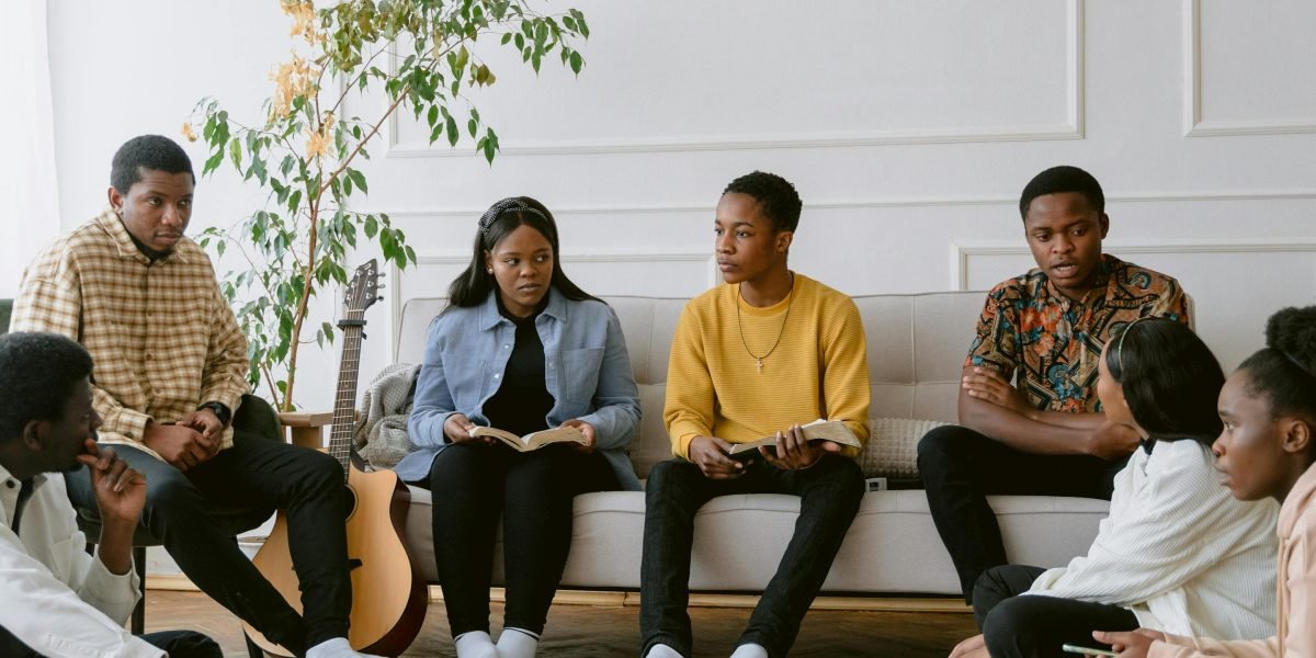 A diverse group of people engaged in lively discussion, likely at a book club meeting.