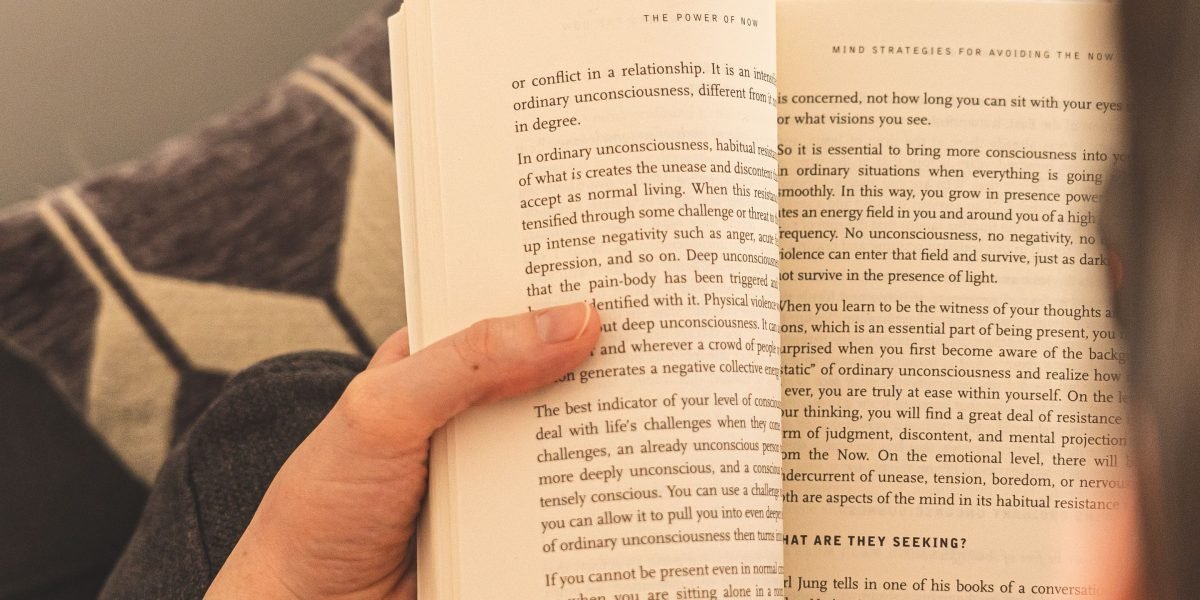A person deeply engrossed in reading a thought-provoking novel, reflecting on its profound themes and hidden worlds.