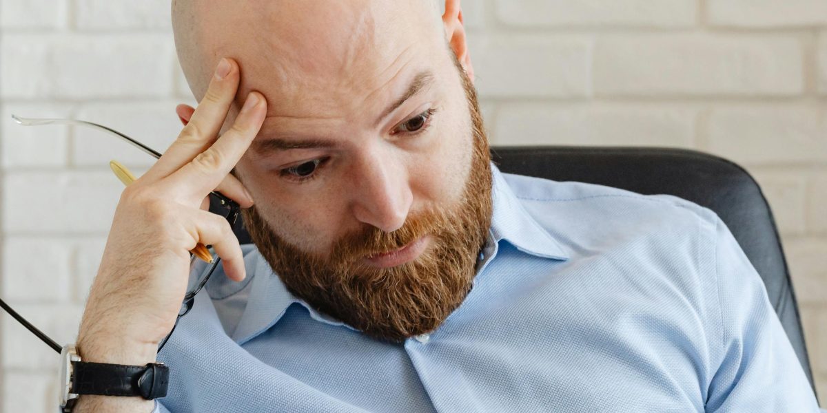 A person in a contemplative or stressed pose, reflecting the intense and morally complex themes often found in dark fantasy.