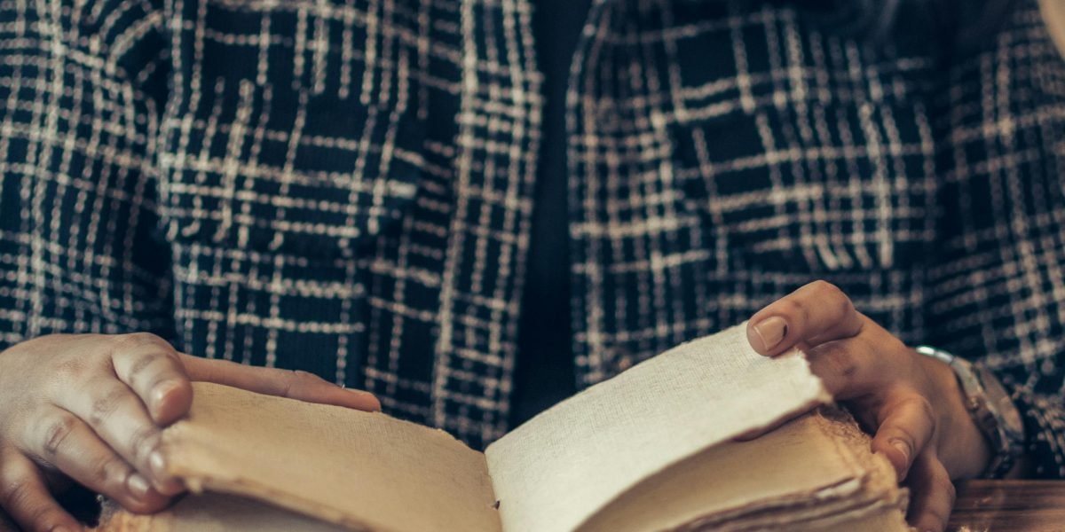 A dedicated reader deeply absorbed in a thick fantasy novel, lost in a sweeping saga.