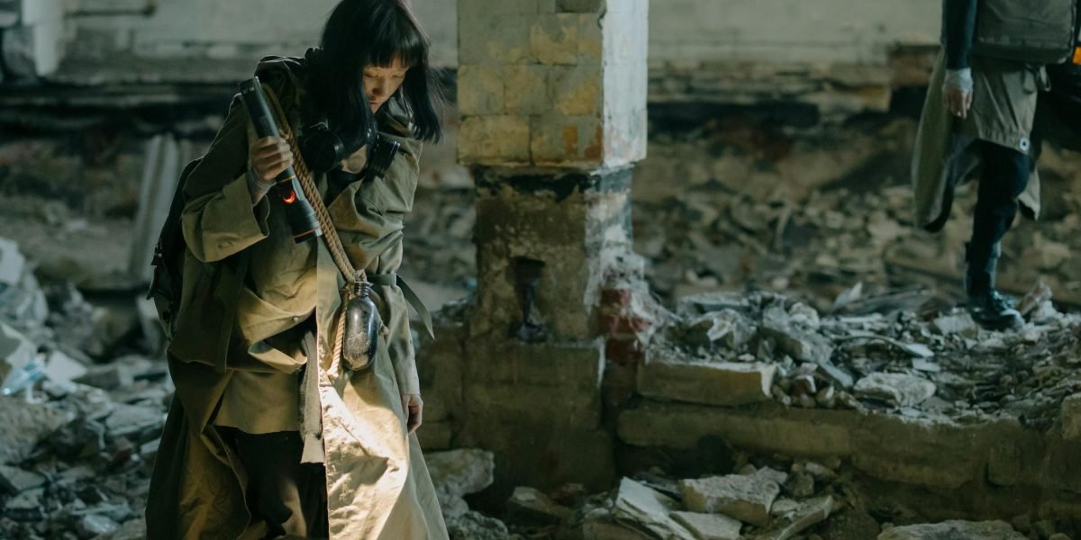 Two individuals navigate a crumbling, futuristic city, symbolizing love amidst a dystopian backdrop.