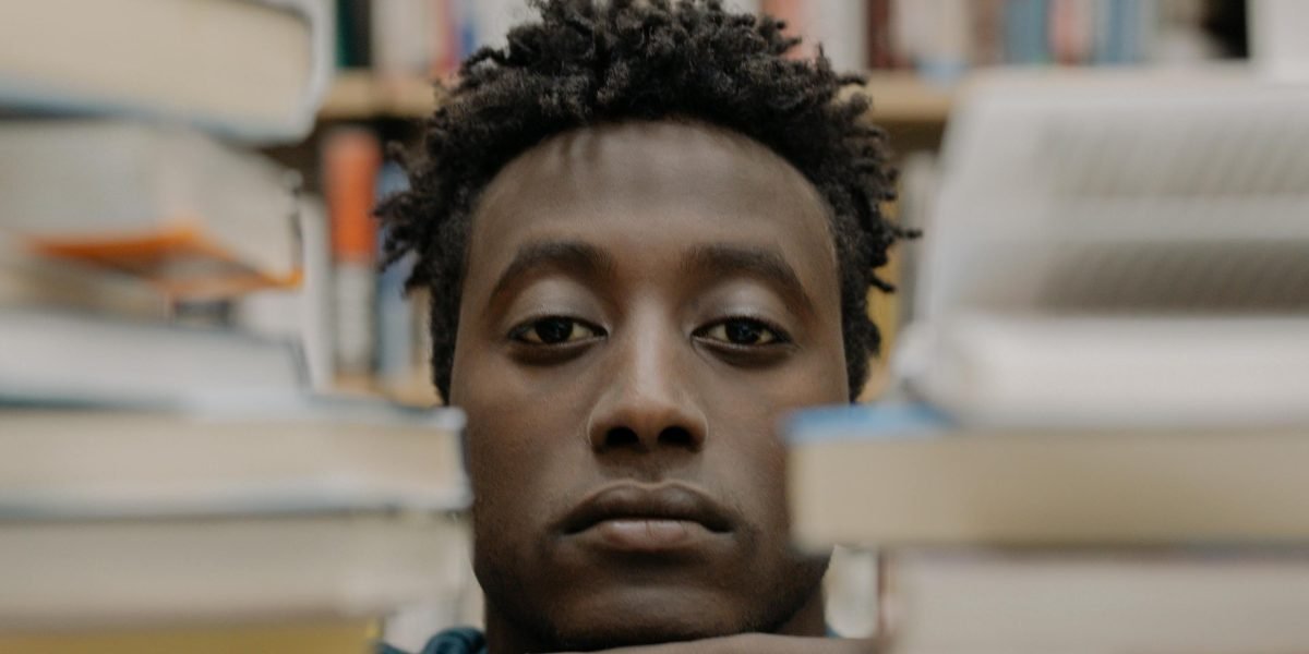 A person looking through bookshelves with a slightly frustrated expression, symbolizing the difficulty of finding specific book types.